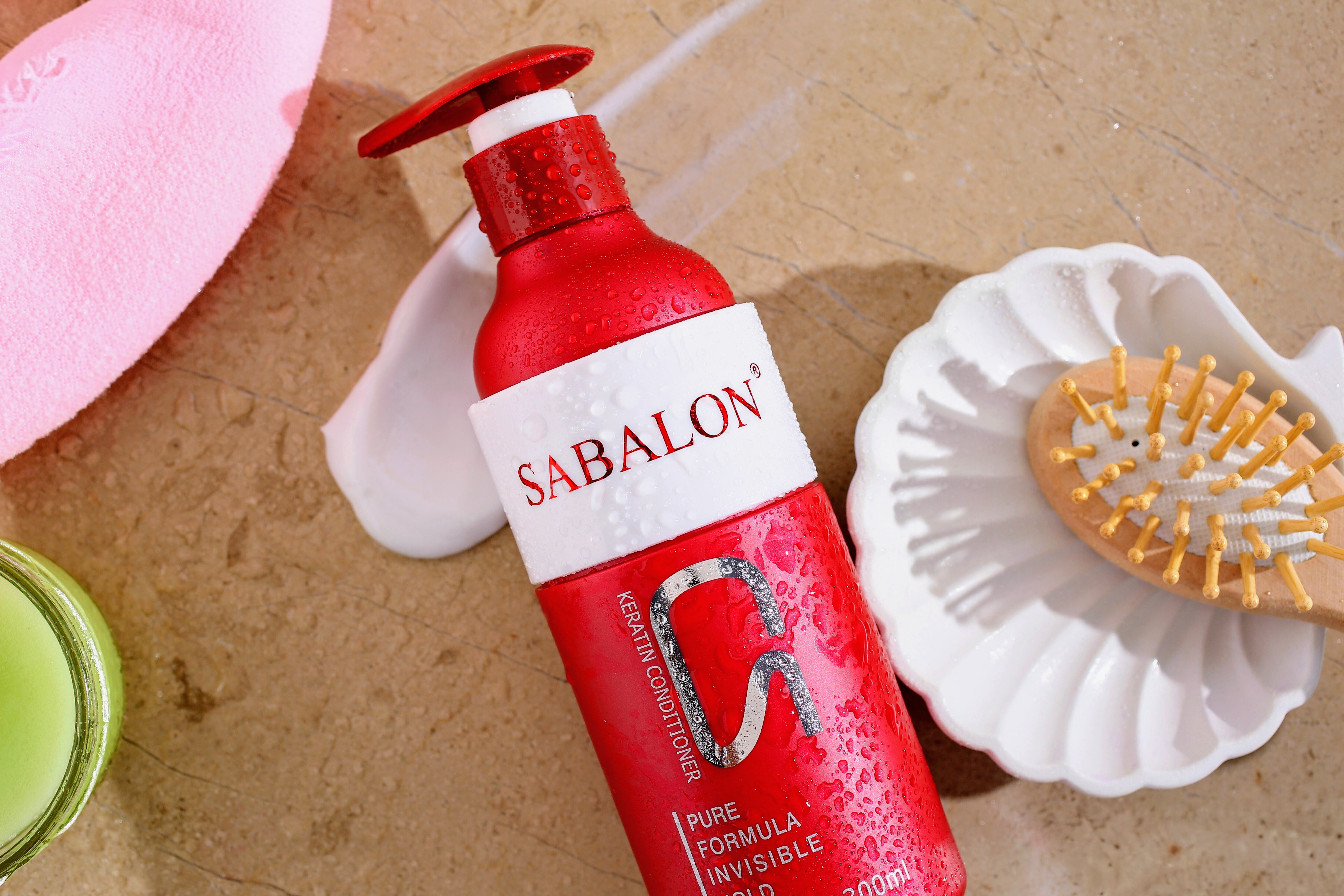 Red Sabalon lotion bottle with pump on textured surface